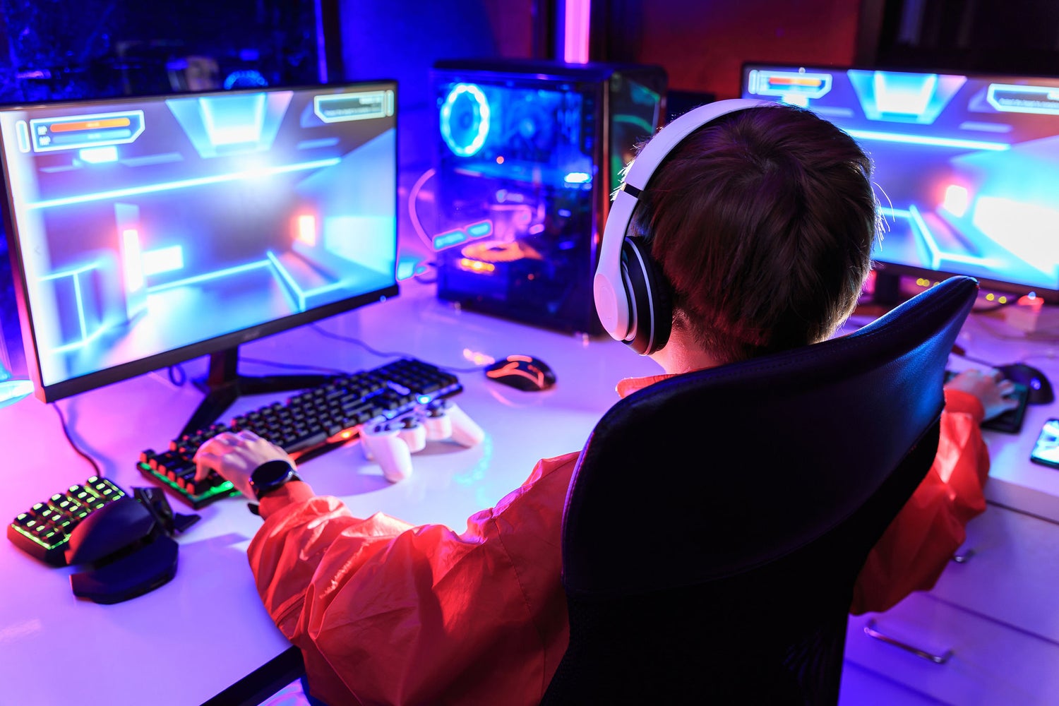 A boy is playing video games while wearing headphones